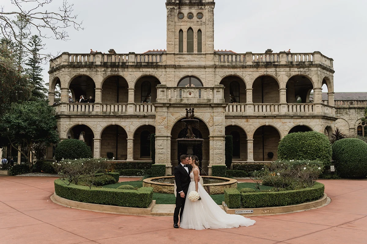 Sydney couple kissing in front of Curzon Hall after ceremony
