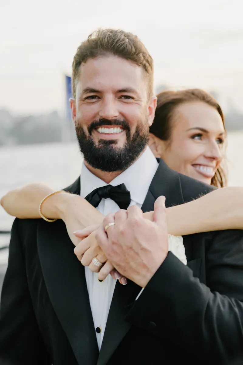 bride embracing groom and showing wedding rings at Aqua Starship Sydney harbour wedding