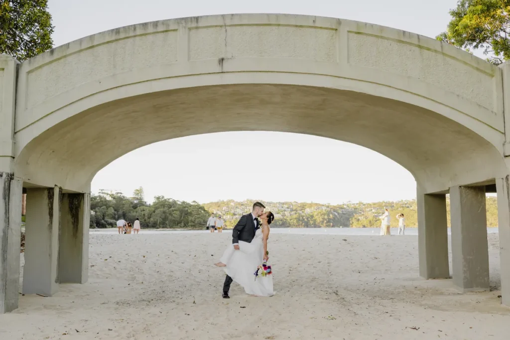 Bride and groom kissing under the arches at Balmoral Beach Sydney