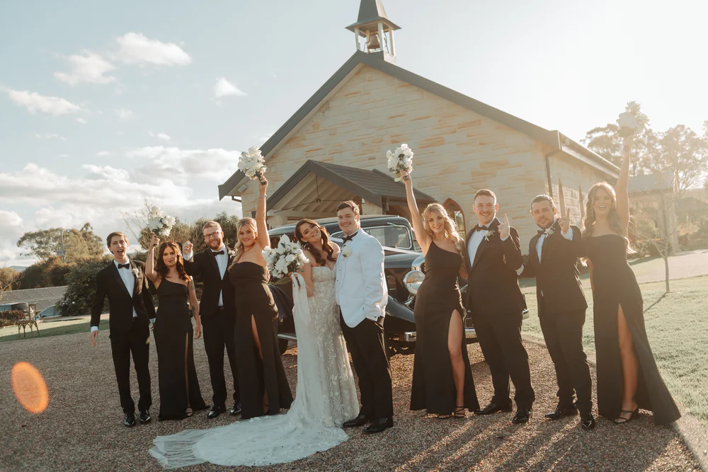 bride and groom portrait session with the bridal party in front of the chapel